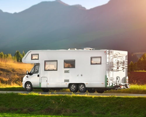 Rv Motorhome Camper Van On The Highway With Bike Rack. Travel Vacation Adventure. Tourists In Rental Campervan. Tourism In Motorhome